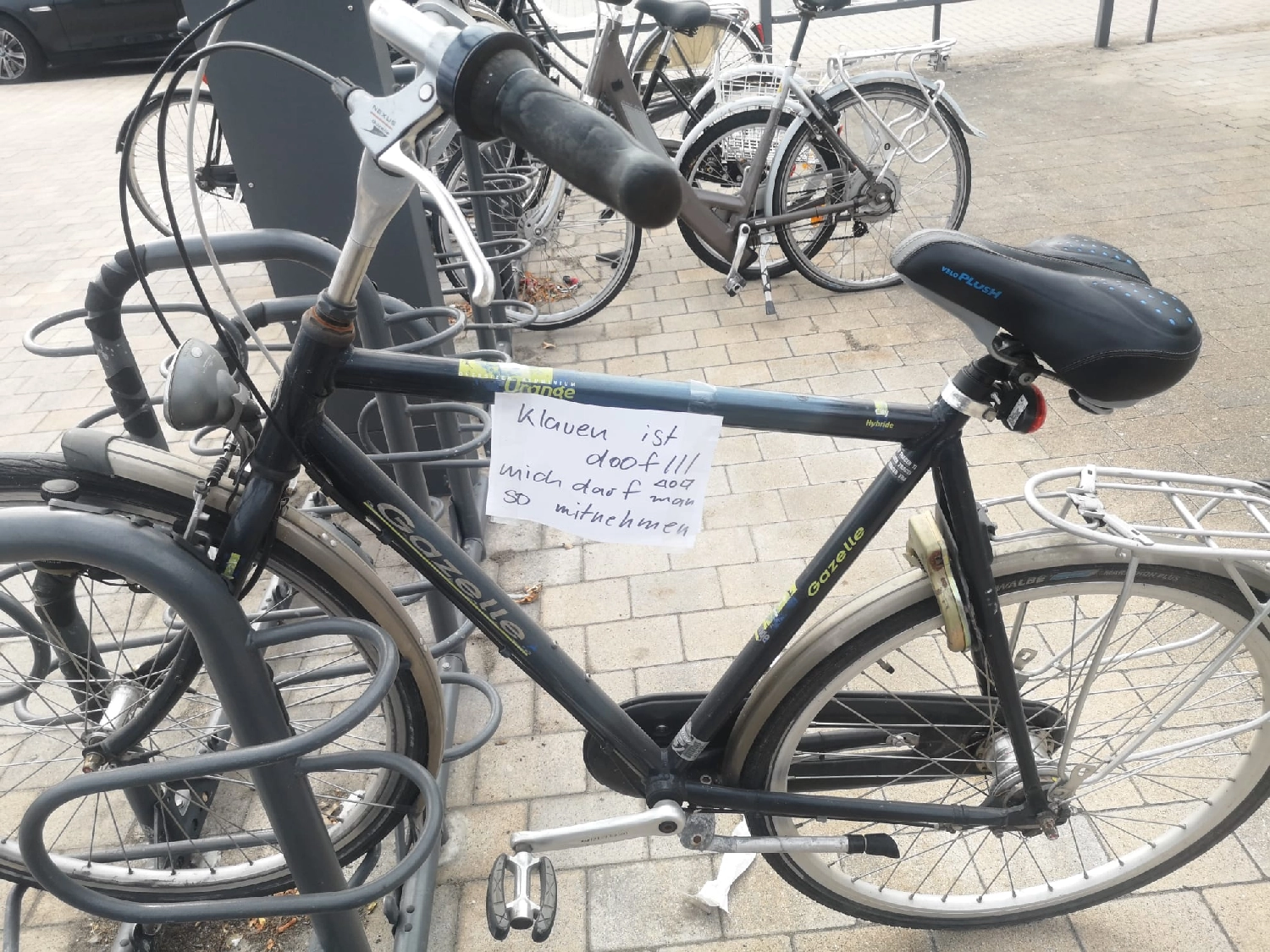 Artloch Prod. - Kunst - Dies ist ein Gazelle Medeo-Stadtfahrrad mit schwarzem Rahmen, das derzeit an einem Fahrradträger befestigt ist.